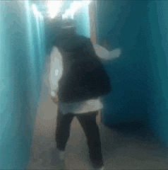 a person is walking through a blue hallway .