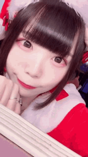 a girl in a santa claus costume is taking a selfie with a mirror .