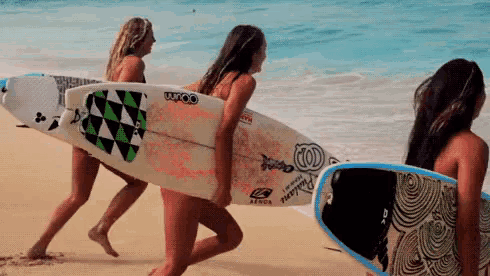 a woman carrying a surfboard that says ocean on the back