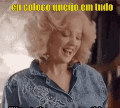 a woman with blonde hair and a denim shirt is smiling and says eu coloco queijo em tudo .