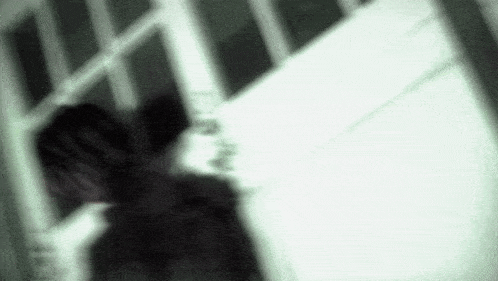 a blurry picture of a person standing in front of a window