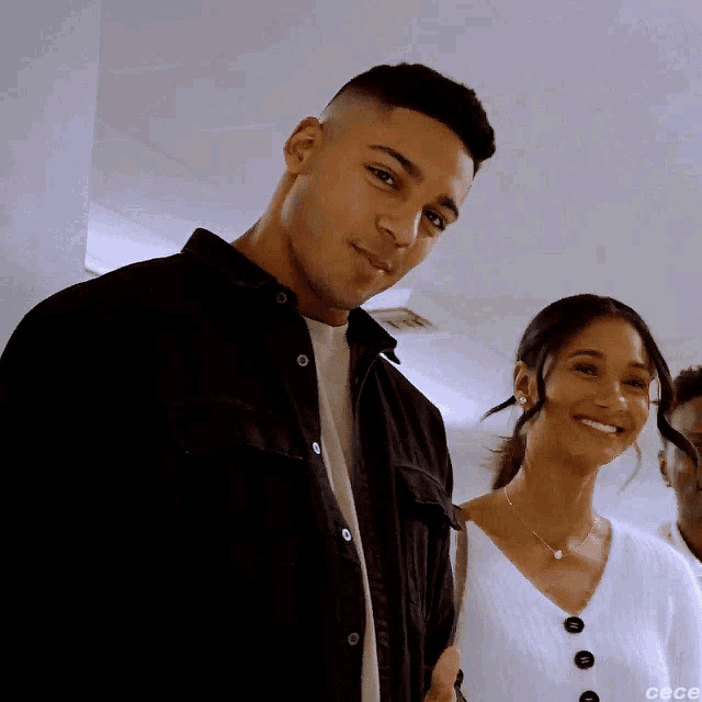 a man and a woman are standing next to each other and smiling .