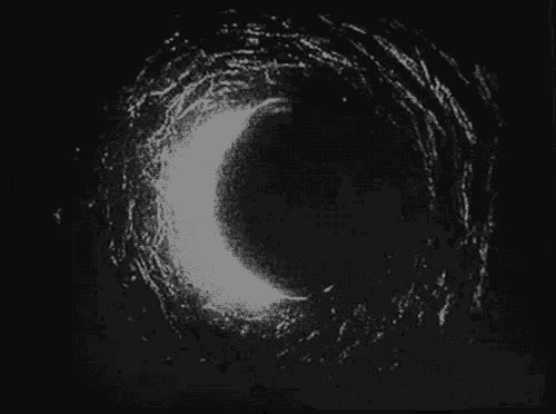 a black and white photo of a circle in the dark .