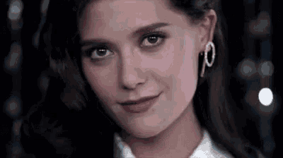 a close up of a woman 's face wearing earrings .