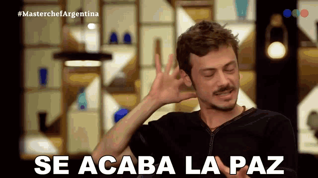 a man covering his ear with his hand and the words se acaba la paz behind him