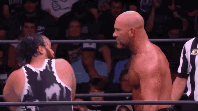 two men in a wrestling ring one of whom is wearing a shirt that says ae