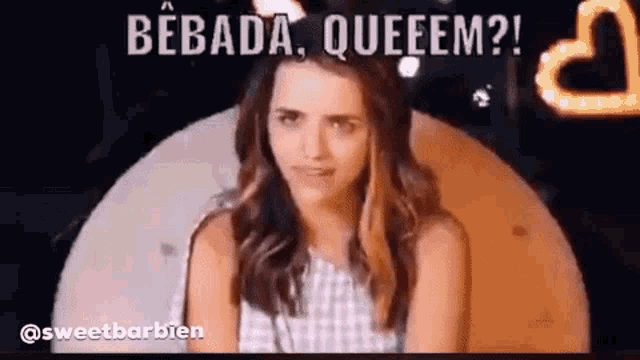 a woman is sitting in front of a sign that says bebada queem .