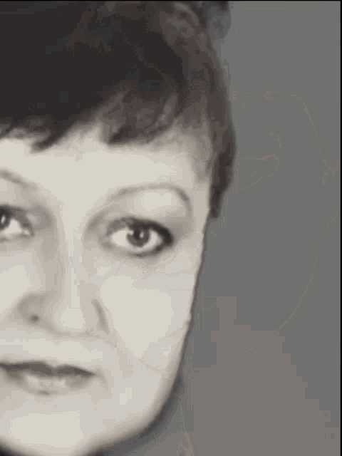a close up of a woman 's face on a gray background