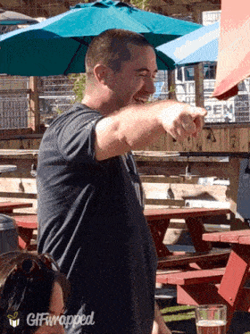a man is pointing at something with a gif wrapped around his neck