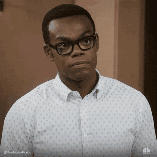 a man wearing glasses and a white shirt is making a face .