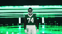 a football player wearing a green jersey with the number 74