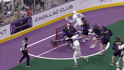 a lacrosse game is being played in front of an advertisement for cadillac club