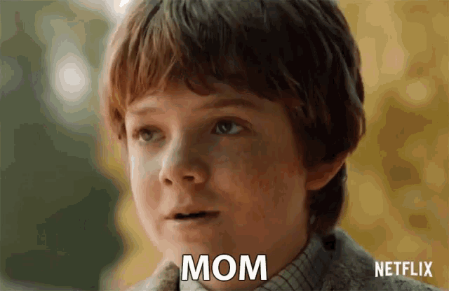 a close up of a boy 's face with the word mom written on it
