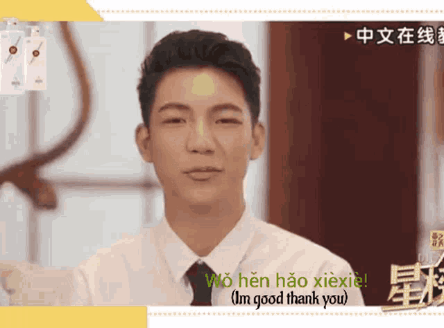a man in a white shirt and tie says wo hen hao xiexie ( i 'm good thank you )