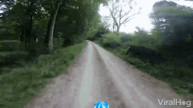 a video of a person riding a bike down a dirt road