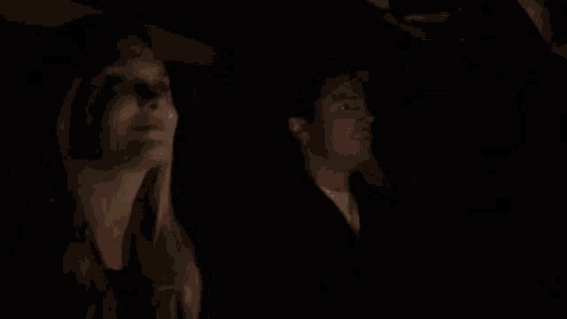a woman and a man are sitting in a car at night .
