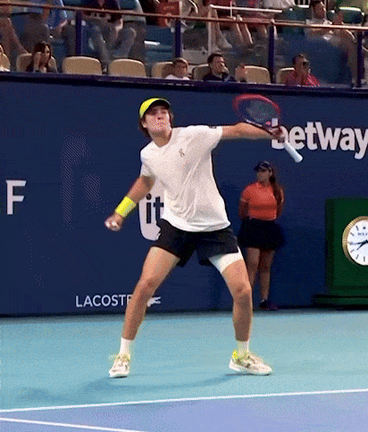 a tennis player is swinging a racket on a court with a sign that says betway on it