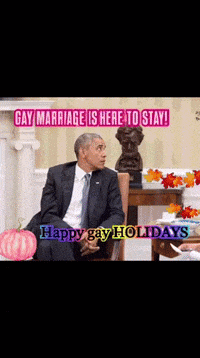 a man in a suit and tie is sitting in front of a fireplace with the words gay marriage is here to stay written above him