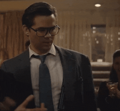 a man in a suit and tie with suspenders and glasses