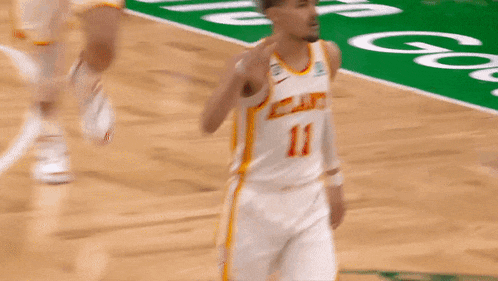 a basketball player with the number 11 on his jersey is walking on the court
