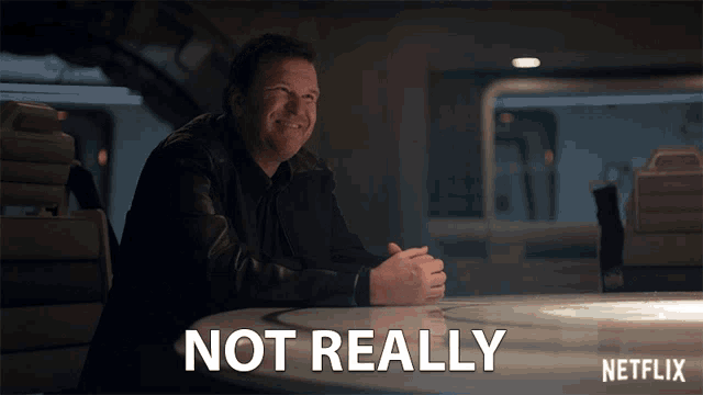 a man sits at a table with the words " not really " written above him