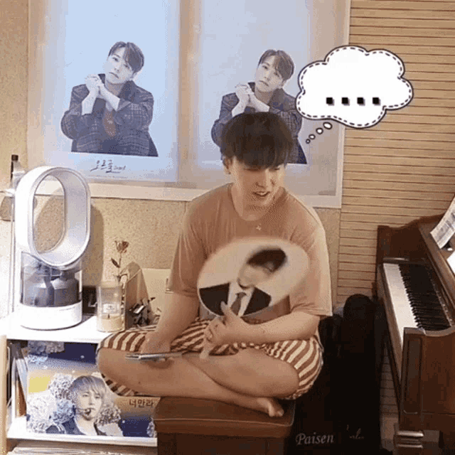 a man sitting on a piano holding a fan with a speech bubble above his head that says " 00 "