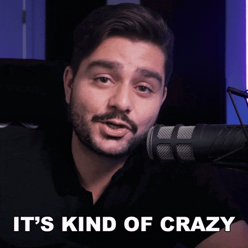 a man in front of a microphone with the words " it 's kind of crazy " above him