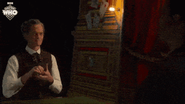 a close up of a person holding a playing card with the doctor who logo in the corner .