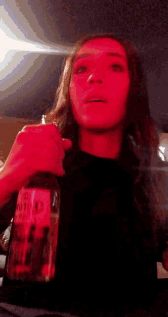 a woman is holding a bottle that says corona extra