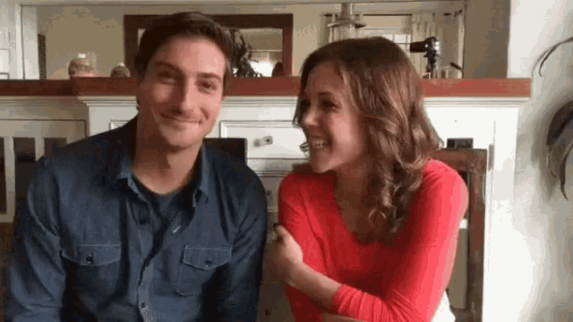 a man and a woman are sitting next to each other and smiling at each other