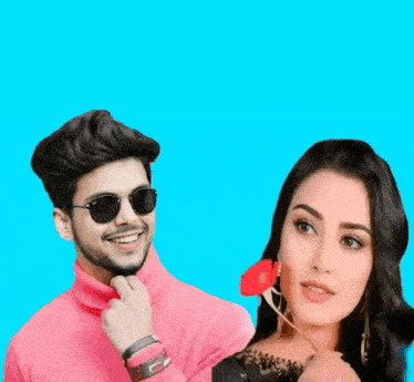 a man wearing sunglasses and a pink turtleneck stands next to a woman with a red flower in her mouth