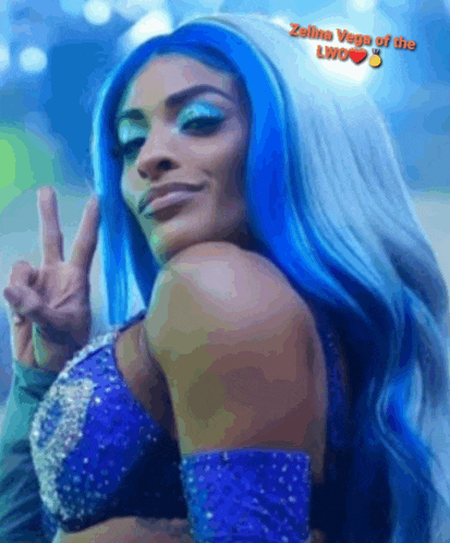 a woman with blue hair is wearing a blue top and giving a peace sign