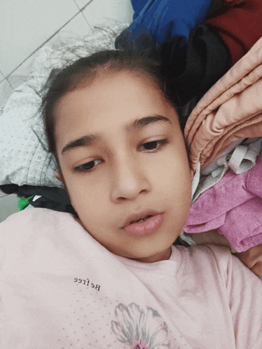 a young girl wearing a pink shirt that says bslgg