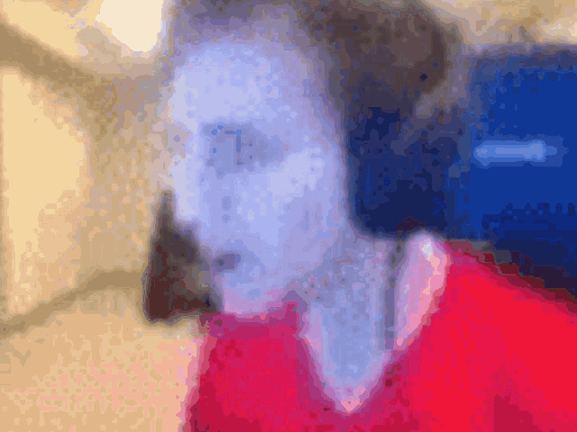 a blurry picture of a person 's face with a red shirt on