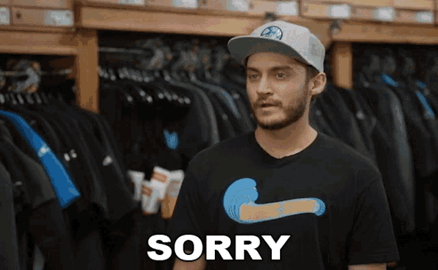 a man wearing a hat and a t-shirt with the word sorry on it