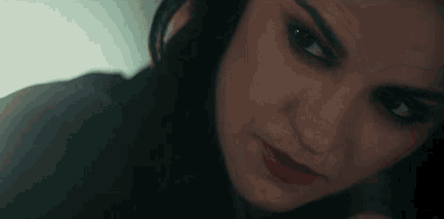 a close up of a woman 's face with red lipstick and black eyeshadow .