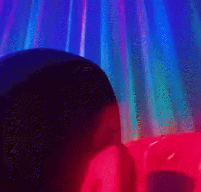 a close up of a person 's face with a red and blue light coming out of it .