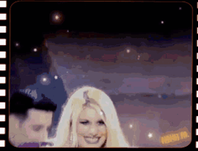 a woman with blonde hair is smiling in a video