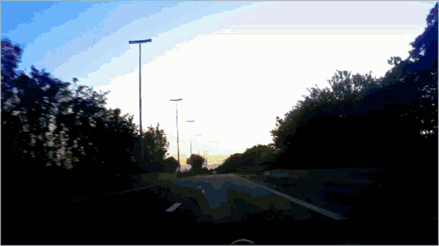 a blurry picture of a road with trees on the side