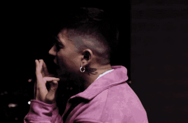 a man with a tattoo on his neck is wearing a pink jacket and a white shirt