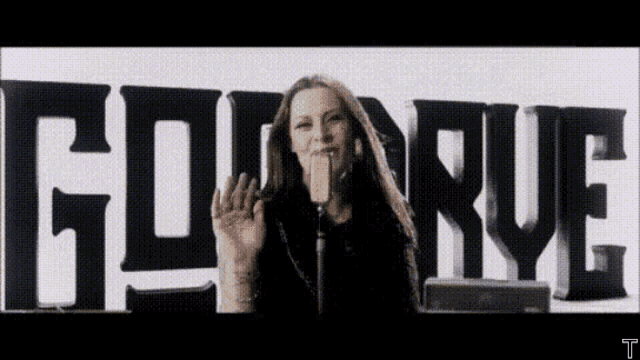 a woman is singing into a microphone in front of a sign that says goin ' rye