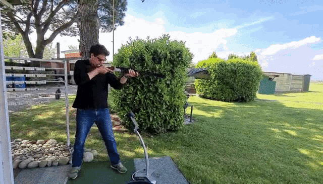 a man in a black shirt is holding a gun