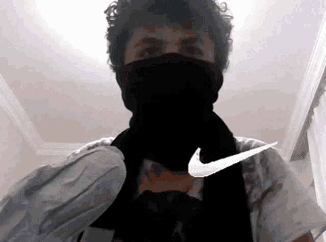 a man wearing a black scarf and a nike logo on his chest