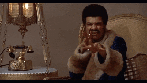 a man in a fur coat is sitting in front of a phone