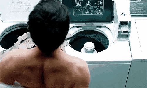 a man is standing in front of a washing machine with the number 4 on the front