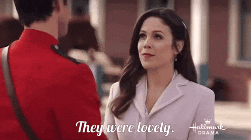 a man in a red uniform and a woman in a white suit are looking at each other .