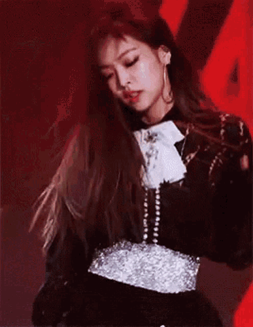 a close up of a woman wearing a black dress and a silver belt .