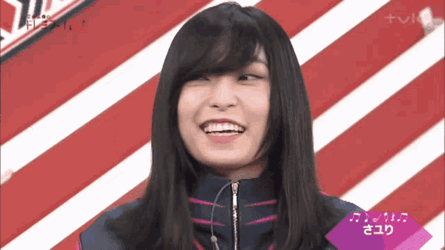 a woman is smiling in front of a striped background