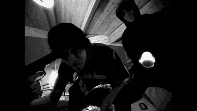 a black and white photo of a man holding a gun and another man holding a flashlight