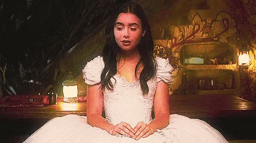 a woman in a white dress is sitting down with her eyes closed